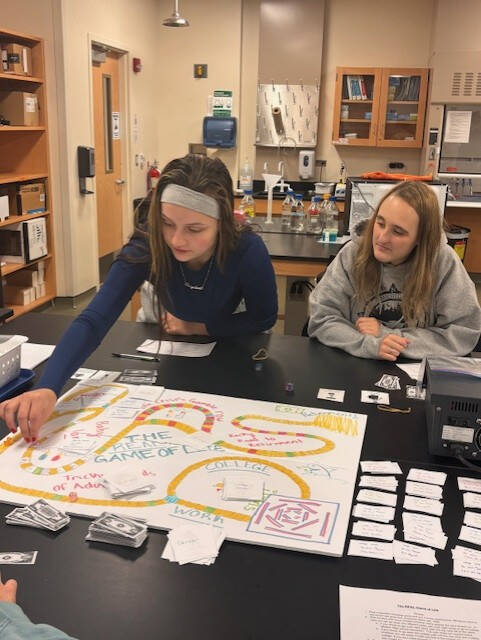 Students playing a homemade boardgame in CMB 250.